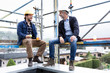© MiJo/Westend61 - Architect and construction worker talking while sitting at construction site