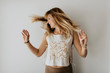 © Sara Monika/Westend61 - Carefree woman shaking head while standing against white wall at home