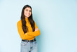 © Asier - Young indian woman isolated on blue background who feels confident, crossing arms with determination.