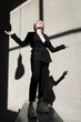 © Tania Cervián/Westend61 - Female professional wearing stylish suit standing on retaining wall with sunlight and shadow in background