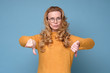 © Viktor Koldunov - Gloomy dissatisfied mature woman looks at camera show thumbs down. Negative feedback, disagreement or dislike