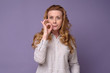 © Viktor Koldunov - Caucasian mature woman showing a sign of silence gesture zipping her mouth. Studio shot.