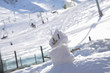 small snowman with snowy slope in the background