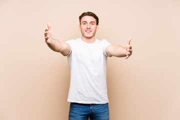 Wall Mural - Young caucasian man posing isolated feels confident giving a hug to the camera.