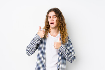 Wall Mural - Young long hair man posing isolated raising both thumbs up, smiling and confident.