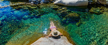 Woman With Hat Bathing In A Turquoise Green River