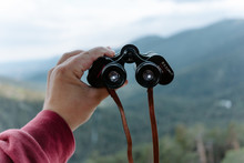 Crop Anonymous Hiker Holding Binoculars While Observing Nature In Mountainous Terrain In Summer Day