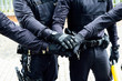 © Jose Luis CARRASCOSA/ADDICTIVE STOCK - anonymous police officers in protective gears and medical masks armed with guns and batons putting hands together while preparing for operation