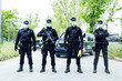 © Jose Luis CARRASCOSA/ADDICTIVE STOCK - Full body squad of Spanish police officers in protective gears with guns wearing medical masks during patrolling street