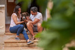 © Philippe Degroote/ADDICTIVE STOCK - Boyfriend and girlfriend sitting on stone steps on street with cute Catahoula Dog while enjoying stroll at weekend
