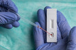 © Ramon Lopez/ADDICTIVE STOCK - Unrecognizable medic in surgical glove examining blood sample while using pipette and professional tool for rapid test on COVID 19