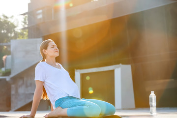 Sticker - Young pregnant woman practicing yoga outdoors