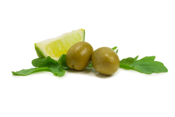 Two olives, piece of lemon and leaves of arugula isolated on white