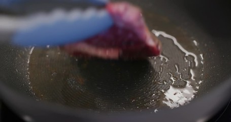 Poster - Fried steak on the pan in kitchen