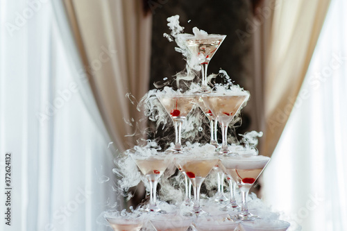 Champagne glass pyramid. Pyramid of glasses of wine, champagne, tower of champagne on wedding party. For festive reception at the wedding on table