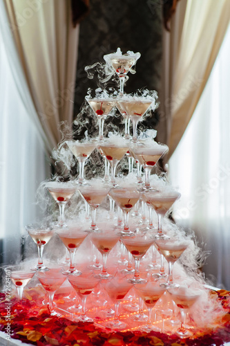Glass of champagne for event party or wedding ceremony. Pyramid of glasses of champagne for celebrate in party with bokeh background. Champagne tower