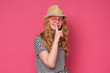 © Viktor Koldunov - Beautiful mature woman wear sunglasses and hat showing silent gesture. Studio shot on pink background.