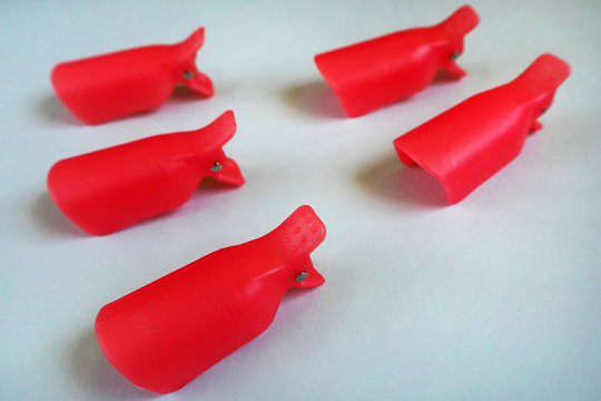 macro five red caps for removing gel Polish from nails on a light blue background