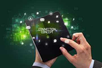 Businessman holding a foldable smartphone with CONNECTION CONCEPT inscription, social networking concept