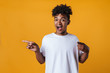 © Drobot Dean - Image of surprised african american guy pointing fingers aside