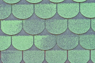 Flexible tile is made of fiberglass impregnated with bitumen. Green roof texture close up.