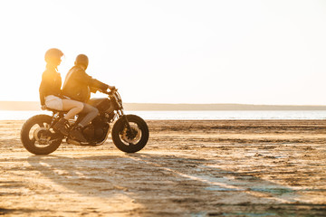 Wall Mural - Beautiful young stylish couple enjoying ride on a motorbike