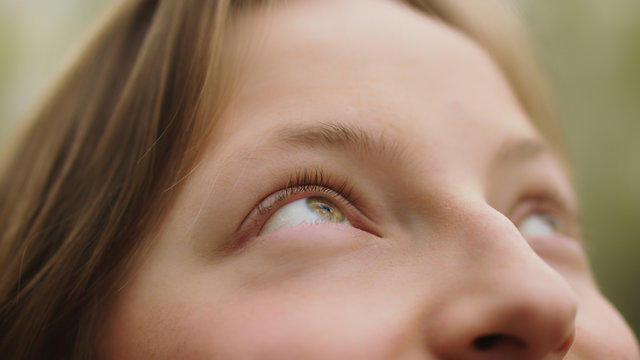 happy young caucasian girl, natural beauty, smiling in nature. extreme close up on her green eyes. h
