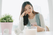 © THESHOTS.CO - Young beautiful pregnant asian woman using smartphone at home.