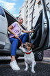 Woman with cute dog getting out of car