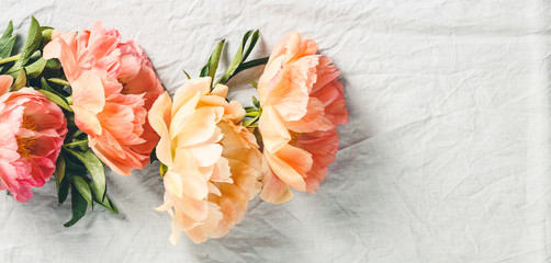 Wall Mural - flat-lay of beautiful peony flowers over grey linen table cloth background, top view, copy space