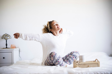 Wall Mural - Beautiful woman wake up in the morning and do breakfast in the bed - bedroom life for healthy people waking up and getting ready to start a new day - white image and background with people