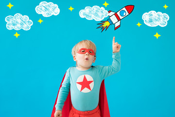 Canvas Print - Portrait of superhero child against blue background