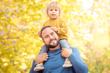 Wall Mural - Happy family having fun outdoor in autumn park