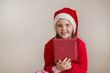 Happy girl in santa costume on light gray background 