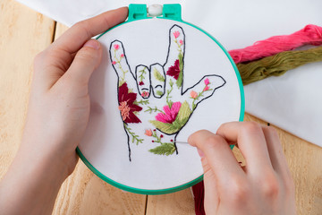 girl embroiders hand embroidery in colors, cool gesture