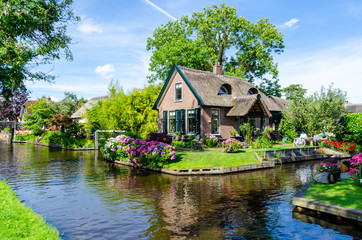 Giethoorn, Netherlands: Landscape view of famous Giethoorn village with canals and rustic thatched roof houses. The beautiful houses and gardening city is know as 