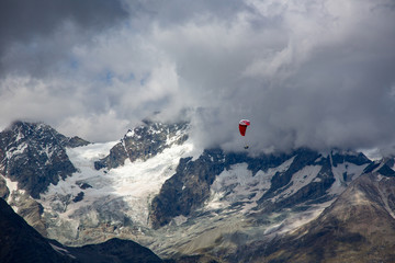 Wall Mural - A paraglider sails over the  Ober Gabelhorn (4063 m).  It is a mountain in the Pennine Alps in Switzerland, located between Zermatt and Zinal.