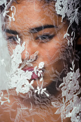 Wall Mural - portrait of beauty young afro woman through white lace, like new bride under veil close up