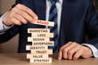 © Nikolai - Businessman in suit building from wooden blocks brand concept.