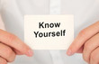 © Sinfebeth - Man's hands take a card with words Know yourself, finance and business concept.