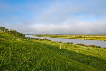 Wall Mural - The river ,cloudscape and morning fog  in the grassland.