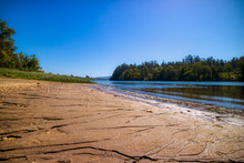 Closeup Shot Of A Sandy Riverbank With A Blue Sky Background