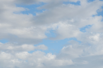 Fluffy white clouds against a blue sky as a nature background
