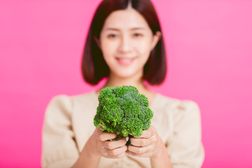 Healthy young woman showing green food