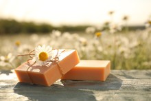 Chamomile Soap Bars On Blue Wooden Table In Field