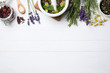 Flat lay composition with healing herbs on white wooden table. Space for text