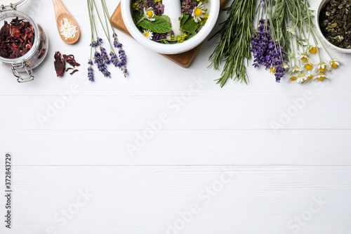 Fototapeta na drzwi i meble Flat lay composition with healing herbs on white wooden table. Space for text