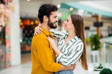 Poster - Profile side photo of positive gentle cute spouses girl husband hug cuddle enjoy valentine day rest relax wear yellow striped shirt in shopping mall center store