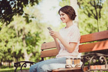 Profile Photo Of Cheerful Charming Young Lady Sit Bench Chatting Subscriber Read Type Content Share Repost Blogging Wait Friend Buy Two Cup Coffee Wear Pink T-shirt Jeans Outside Park