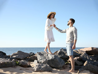 Poster - Happy young couple walking at beach. Honeymoon trip